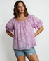 Woman wearing a light purple blouse with ruffled sleeves on a white background