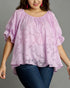 Woman wearing a light purple blouse with floral pattern and blue jeans on a gray background