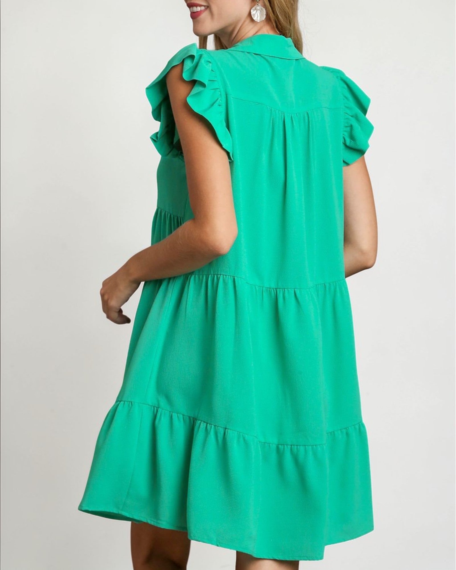 Green dress with ruffled sleeves on a plain background