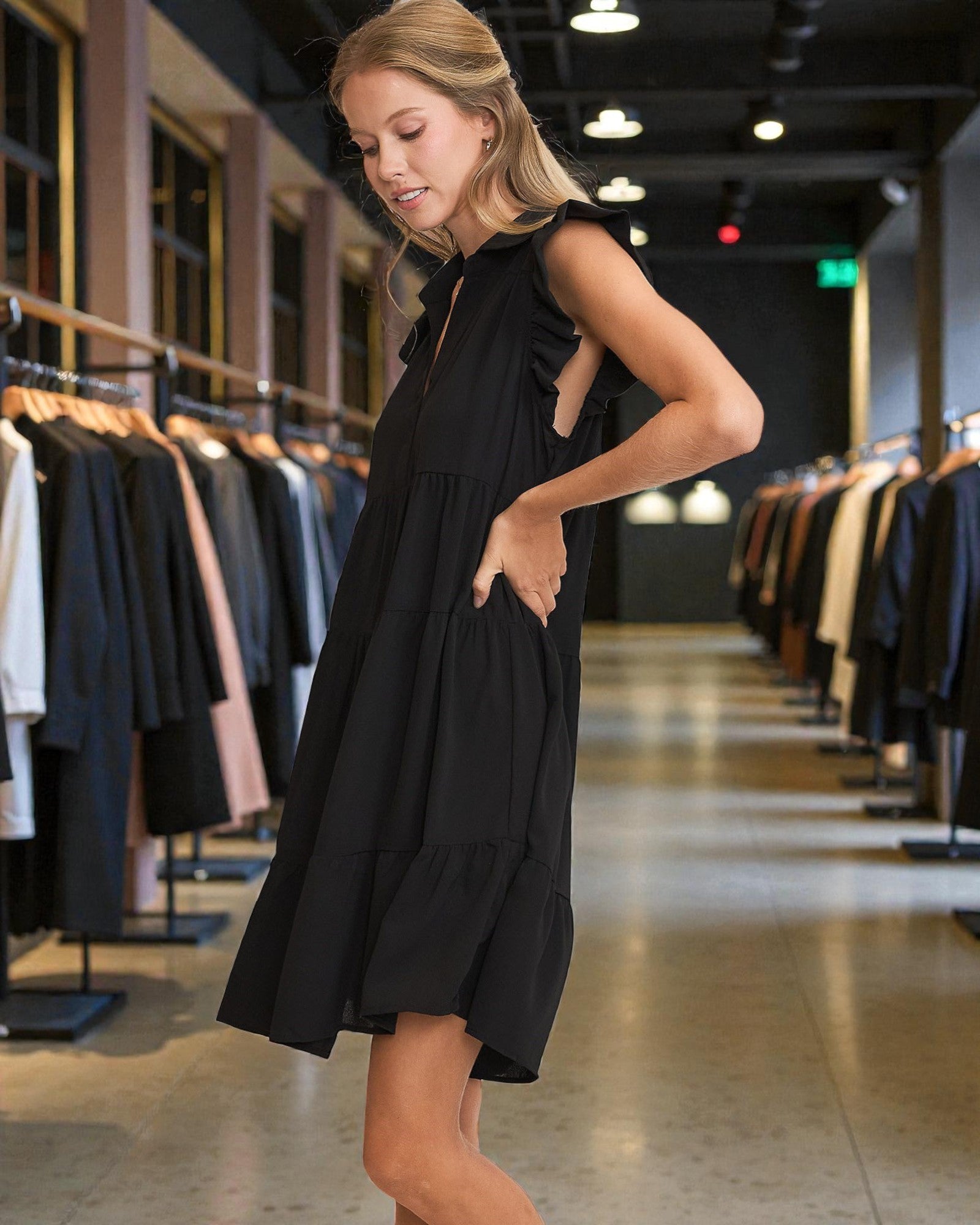 Woman trying on a black dress in a clothing store.