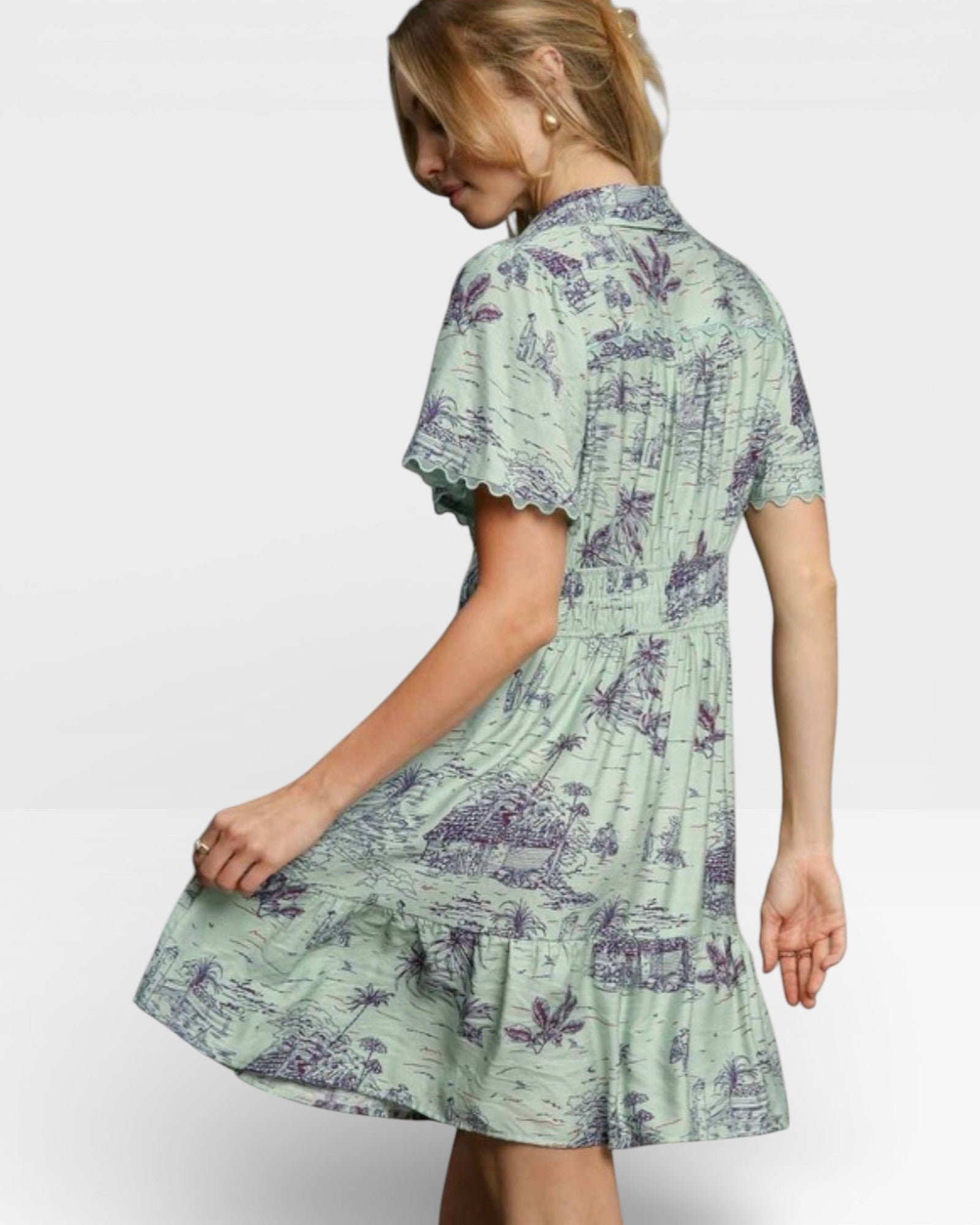Woman wearing a green dress with purple floral pattern on a white background