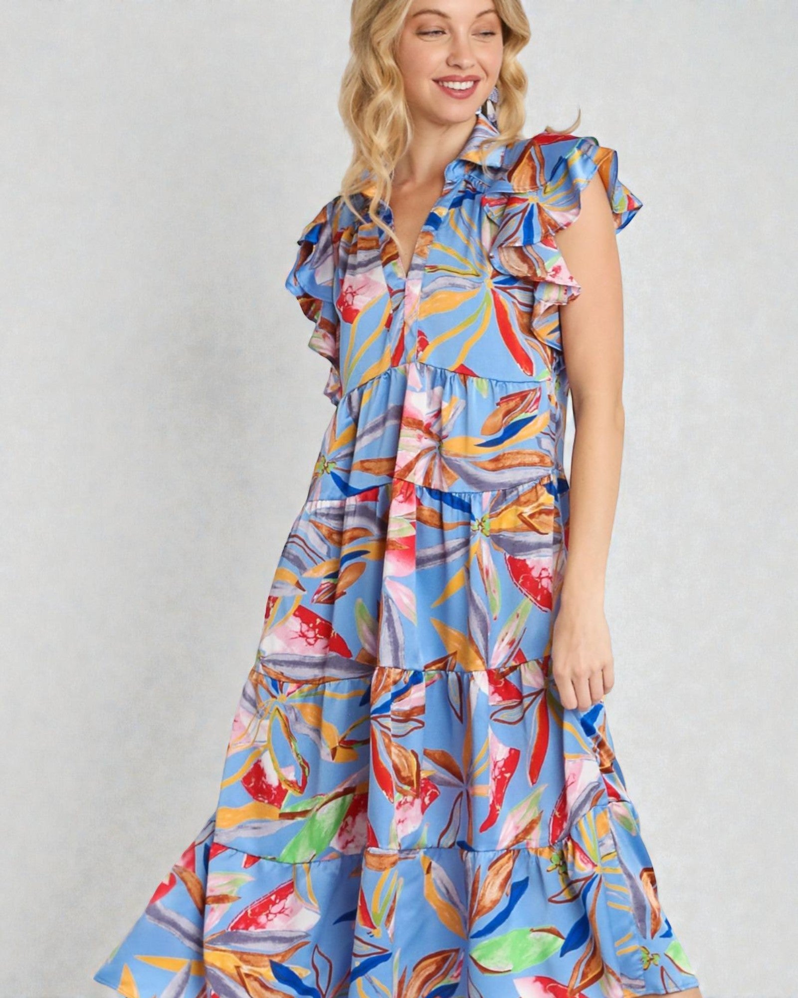 Woman wearing a colorful floral dress on a plain background