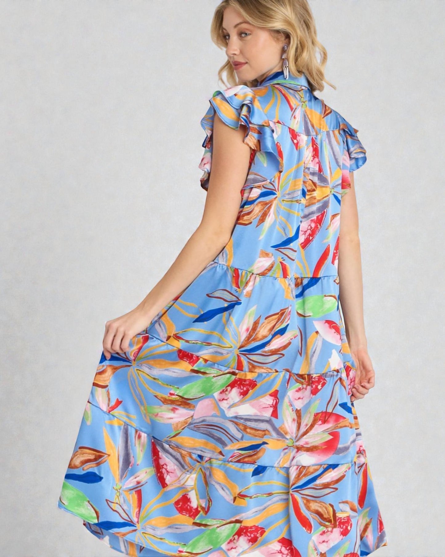 Woman wearing a colorful floral dress on a gray background