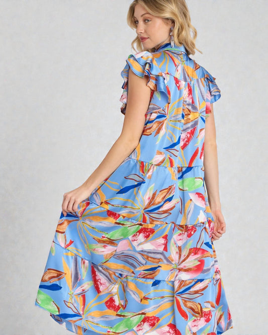 Woman wearing a colorful floral dress on a gray background