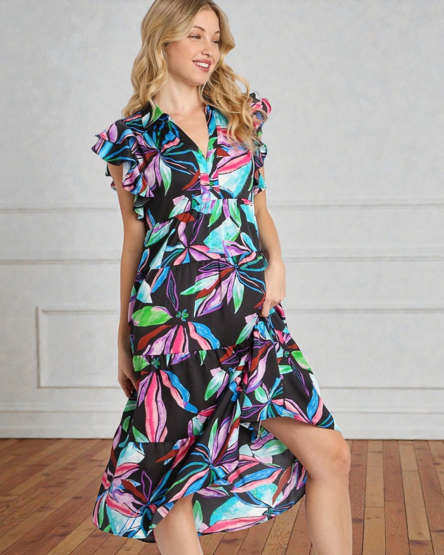 Woman wearing a colorful floral dress against a plain background