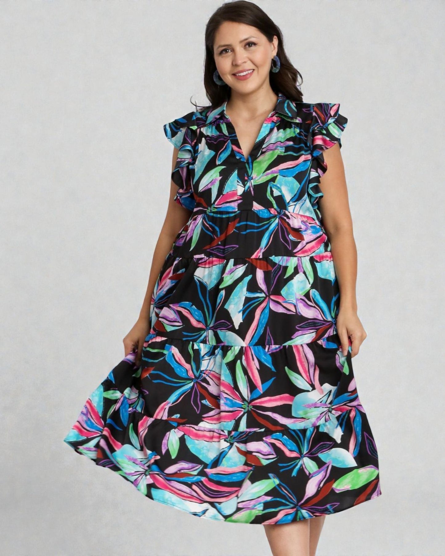 Woman wearing a colorful floral dress on a plain background