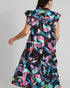 Woman wearing a colorful floral dress with ruffled sleeves on a plain background