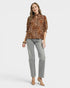Woman wearing a leopard print blouse and gray pants on a white background