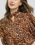 Leopard print blouse worn by a person on a white background