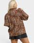 Person wearing a leopard print jacket on a plain background