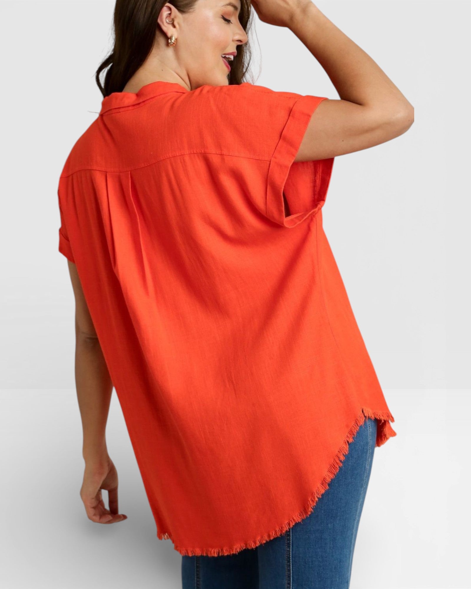Woman wearing an orange shirt with a white background