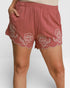 Pink shorts with floral embroidery on a white background