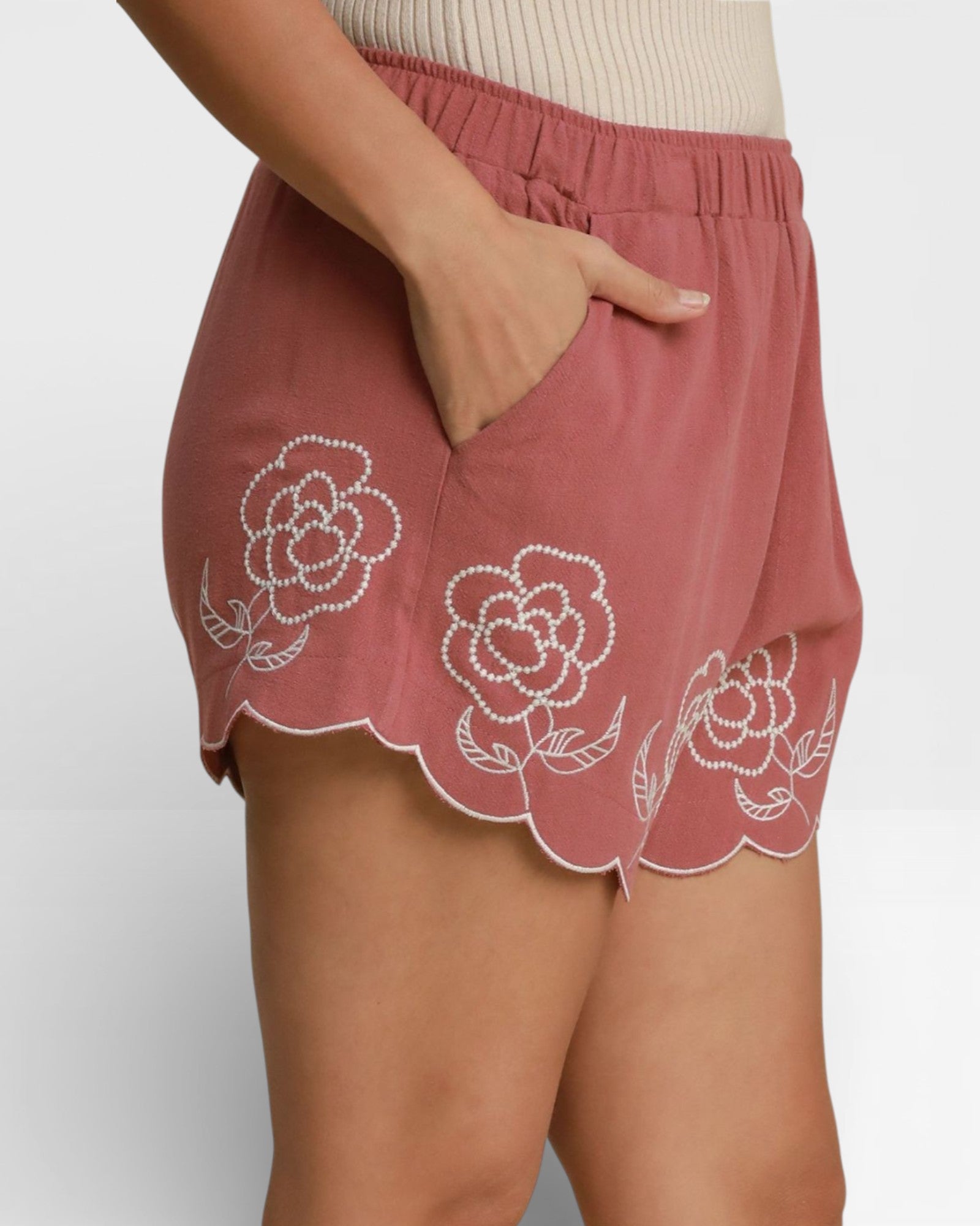 Pink shorts with floral embroidery on a plain background