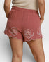 Red shorts with floral embroidery on a plain background