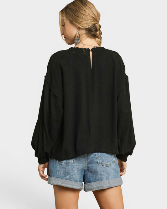 Person wearing a black top and denim shorts on a white background