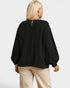 Person wearing a black blouse with balloon sleeves on a white background