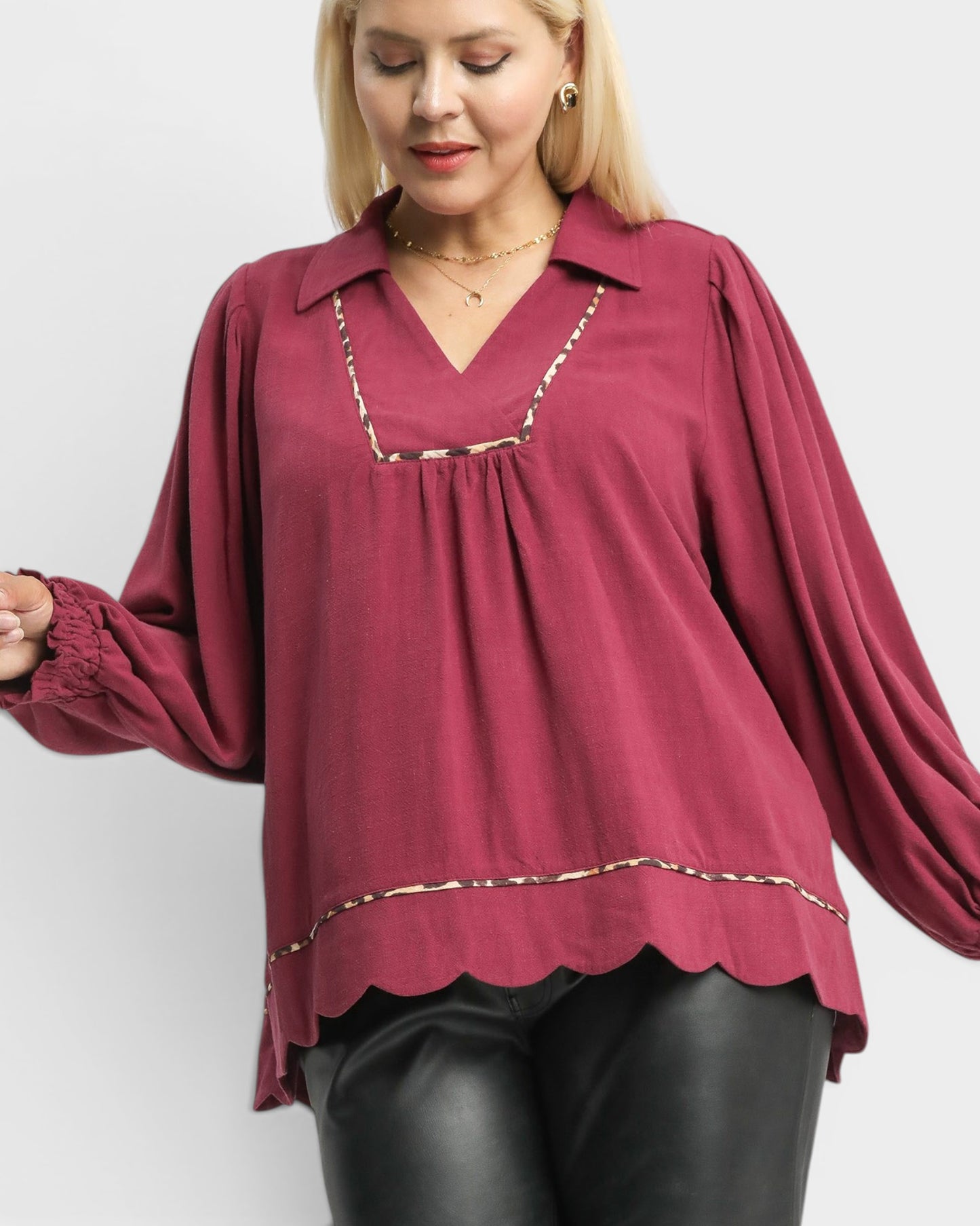 Woman wearing a burgundy blouse with a white background