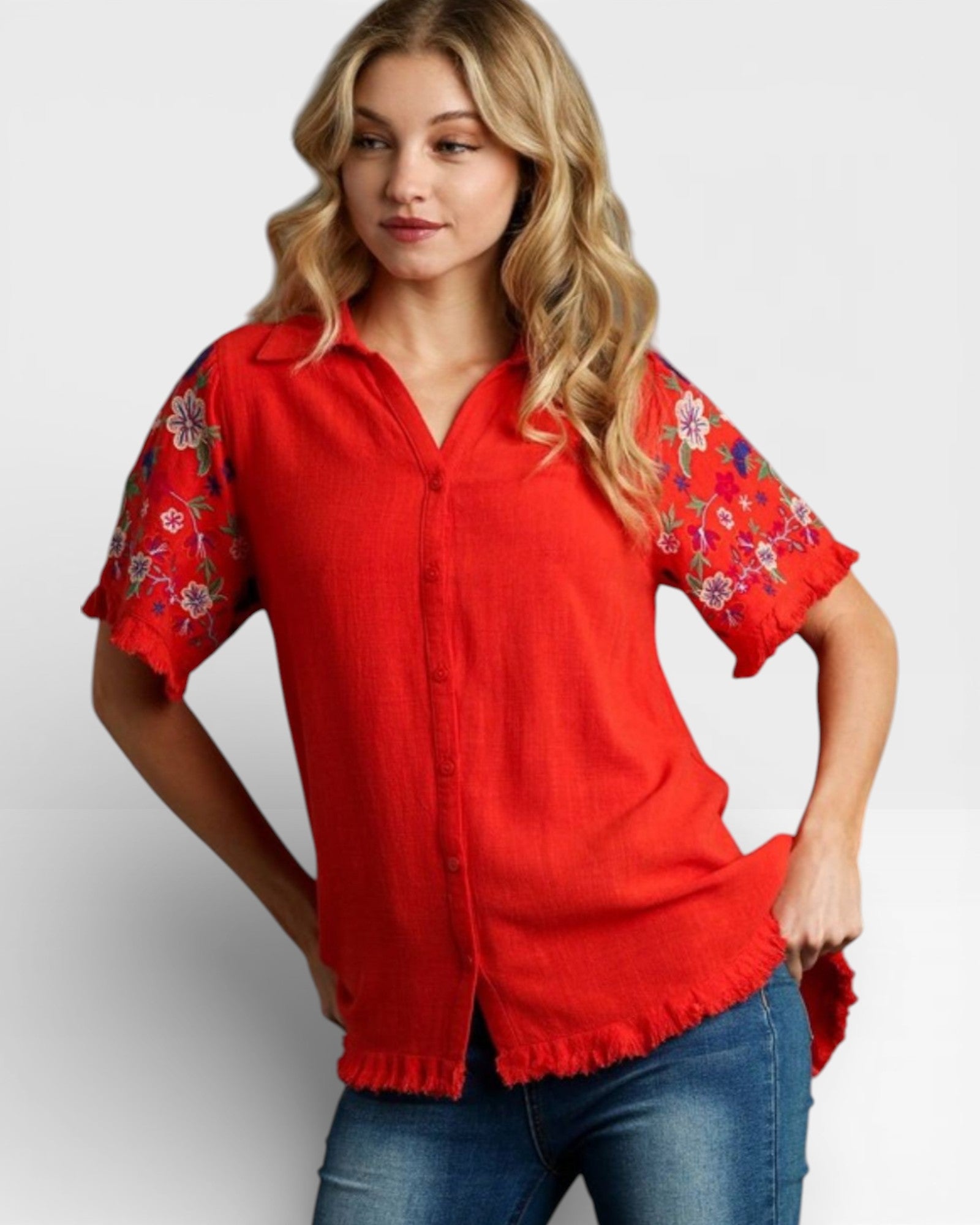 Woman wearing a red blouse with floral sleeves on a white background