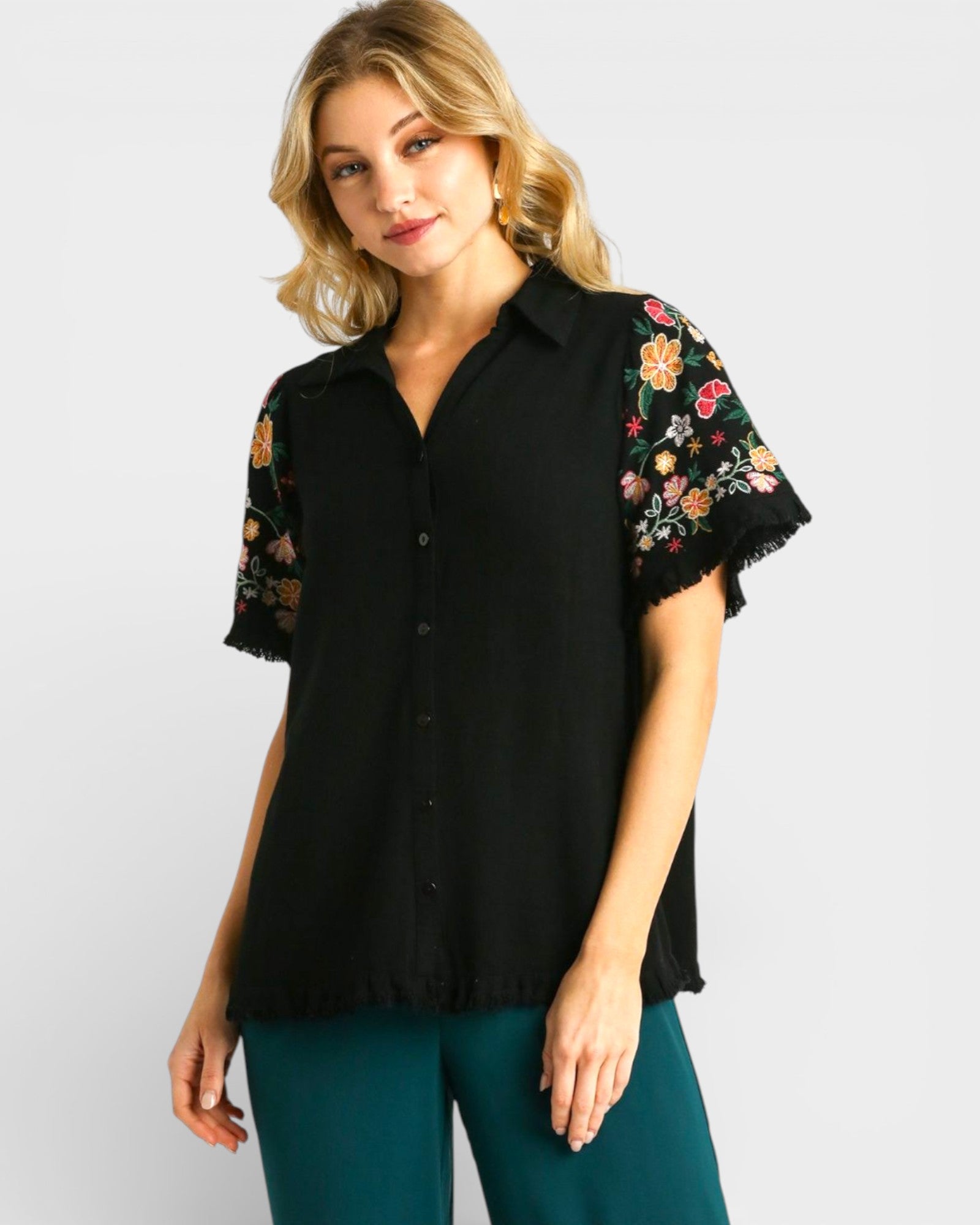 Woman wearing a black blouse with floral sleeves on a white background