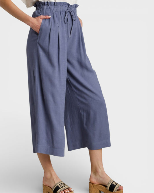 Blue wide-leg pants worn by a person on a white background