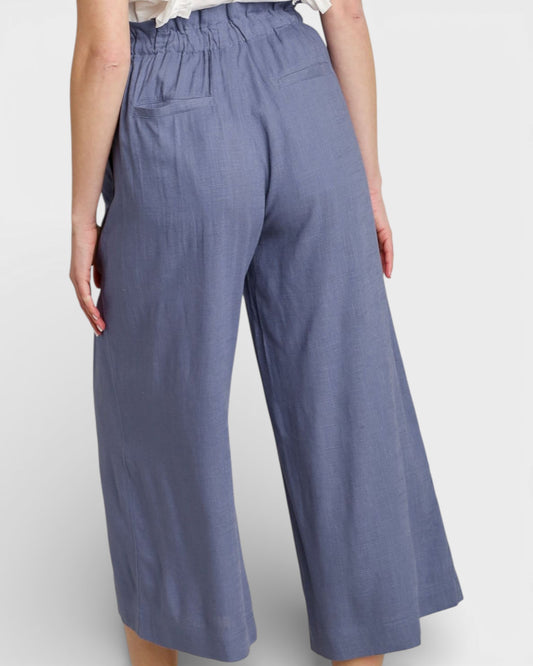 Blue wide-leg pants worn by a person on a white background