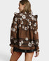 Woman wearing a brown floral blouse with a white background