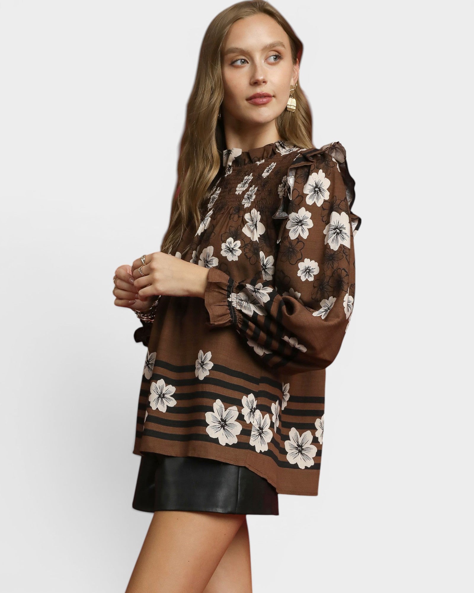 Woman wearing a brown floral blouse with a plain background