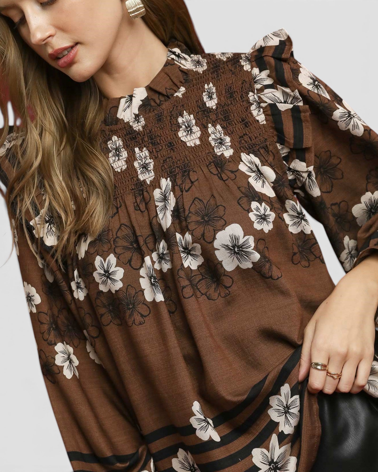 Woman wearing a brown floral dress with a plain background