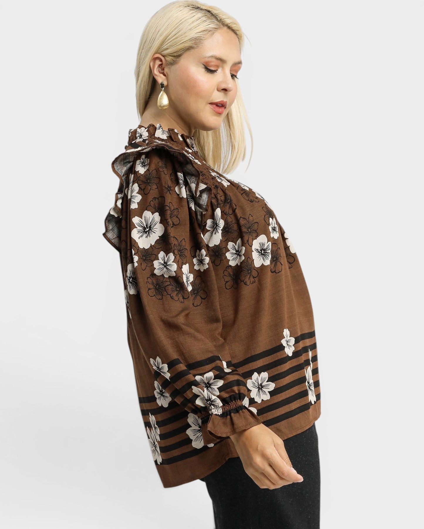 Woman wearing a brown floral blouse on a white background