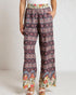 Woman wearing patterned pants on a plain background