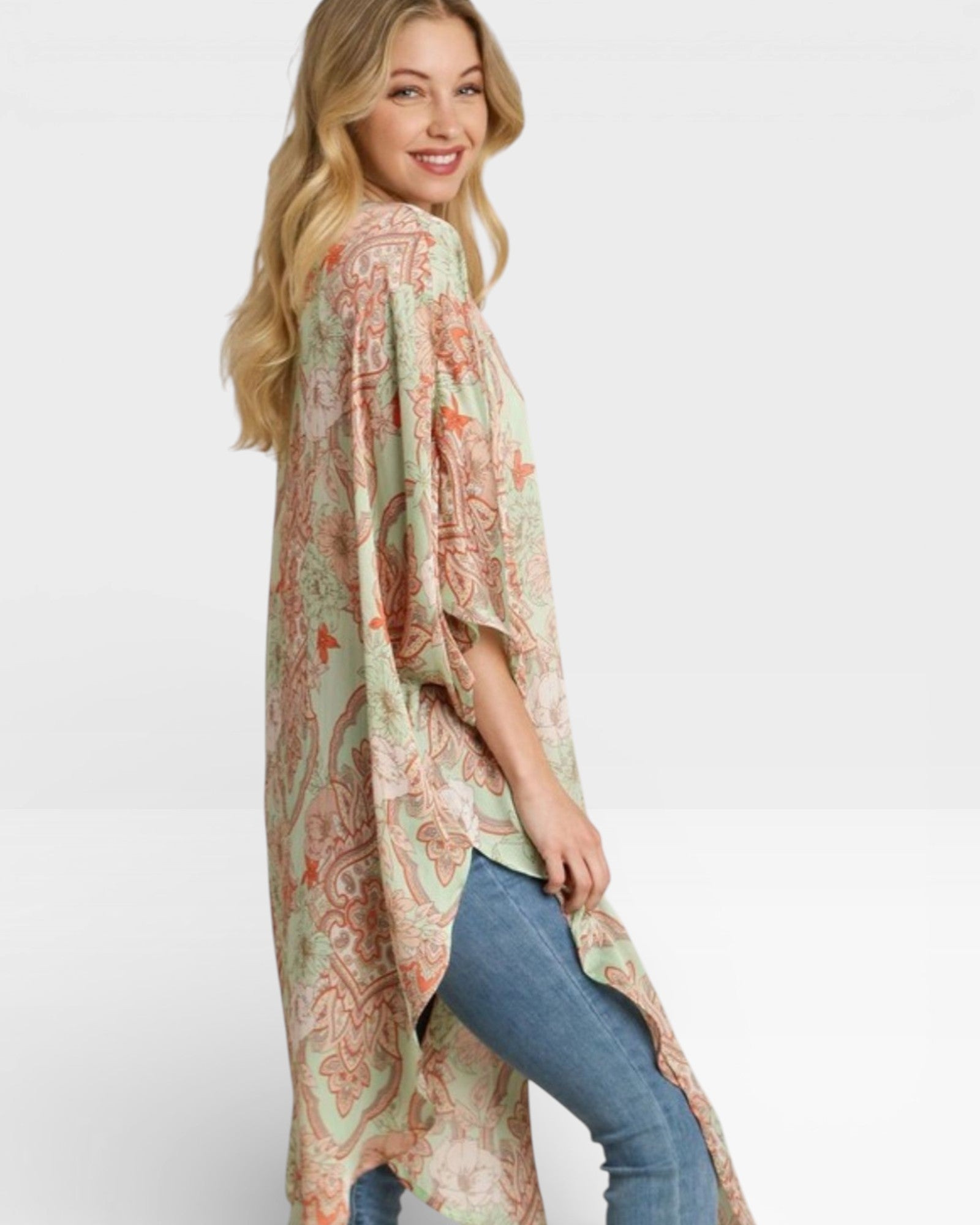 Woman wearing a long, patterned kimono-style garment on a plain background