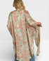 Woman wearing a patterned green and orange kimono-style top on a white background