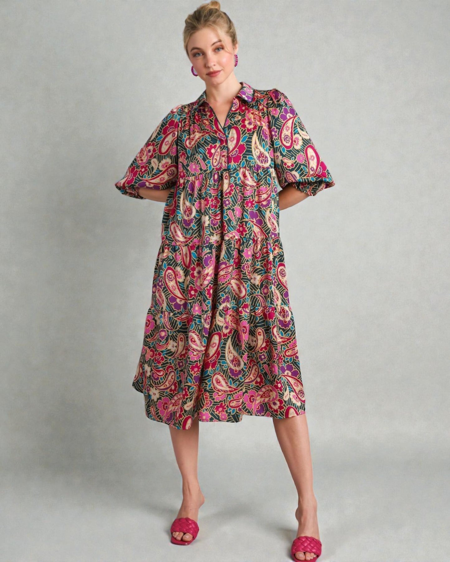 Woman wearing a colorful patterned dress on a gray background