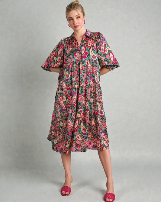 Woman wearing a colorful patterned dress on a gray background