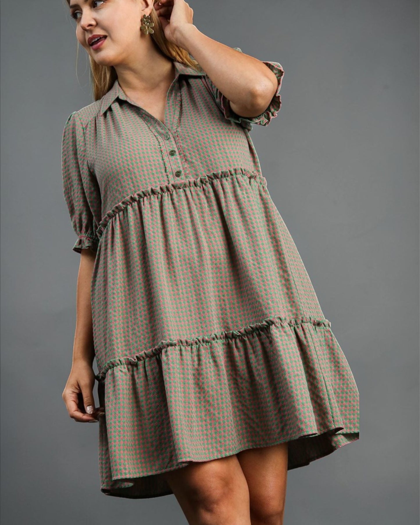 Woman wearing a patterned dress against a gray background