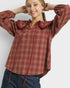 Woman wearing a red plaid shirt with a ruffled collar on a white background