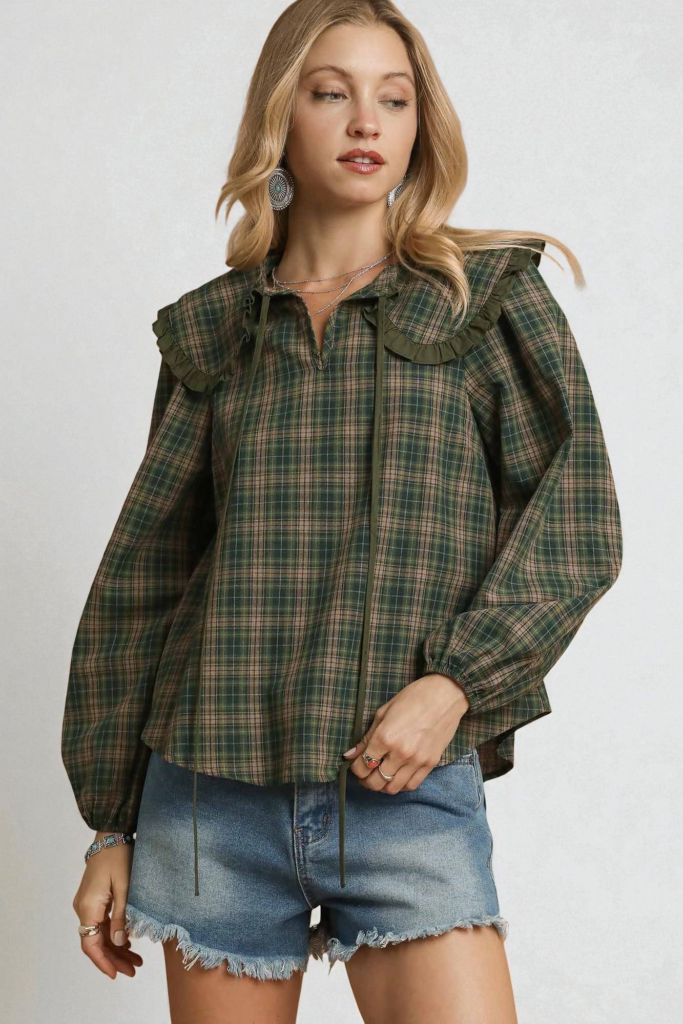Woman wearing a plaid shirt and denim shorts on a white background