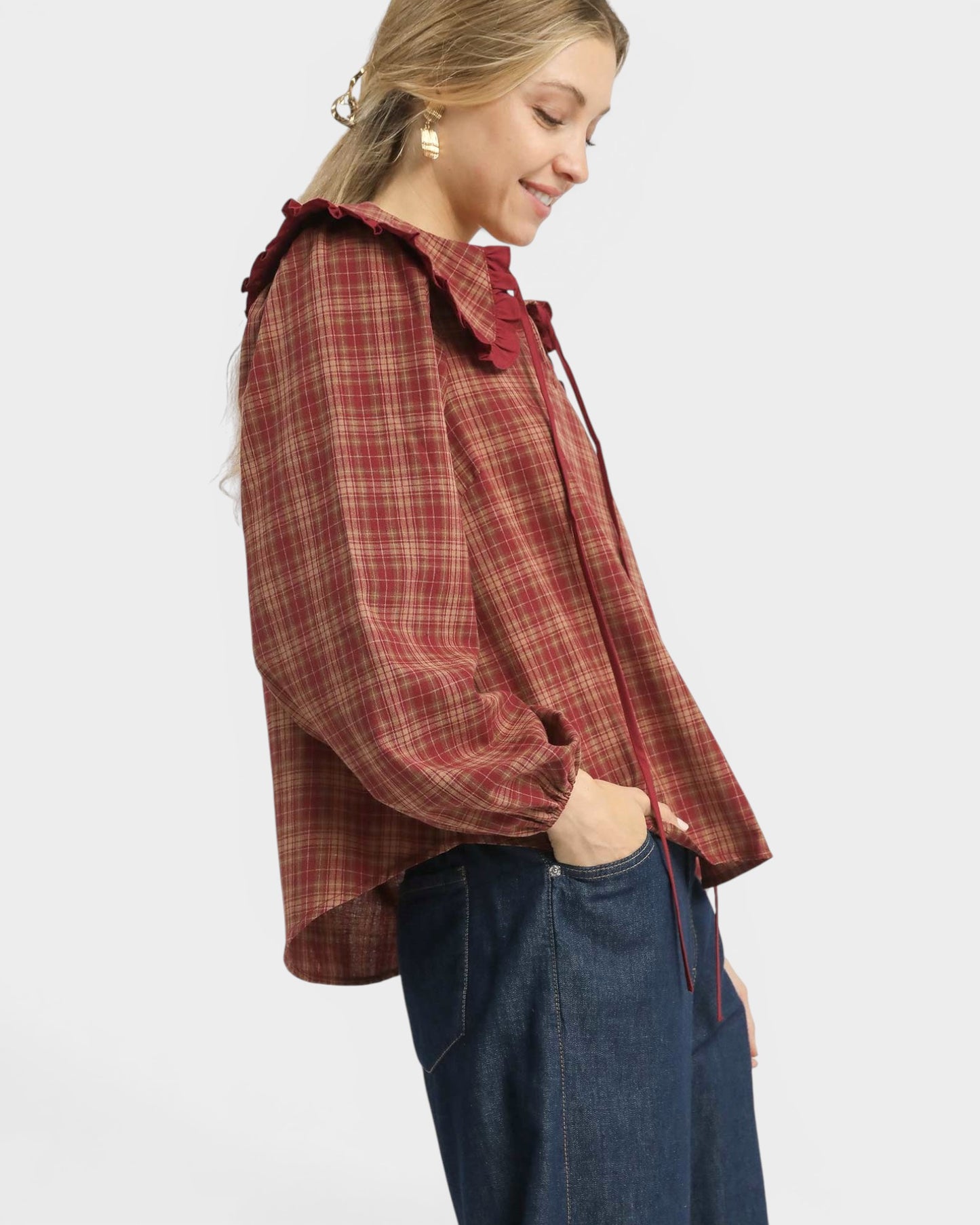 Woman wearing a red plaid shirt and blue jeans on a white background