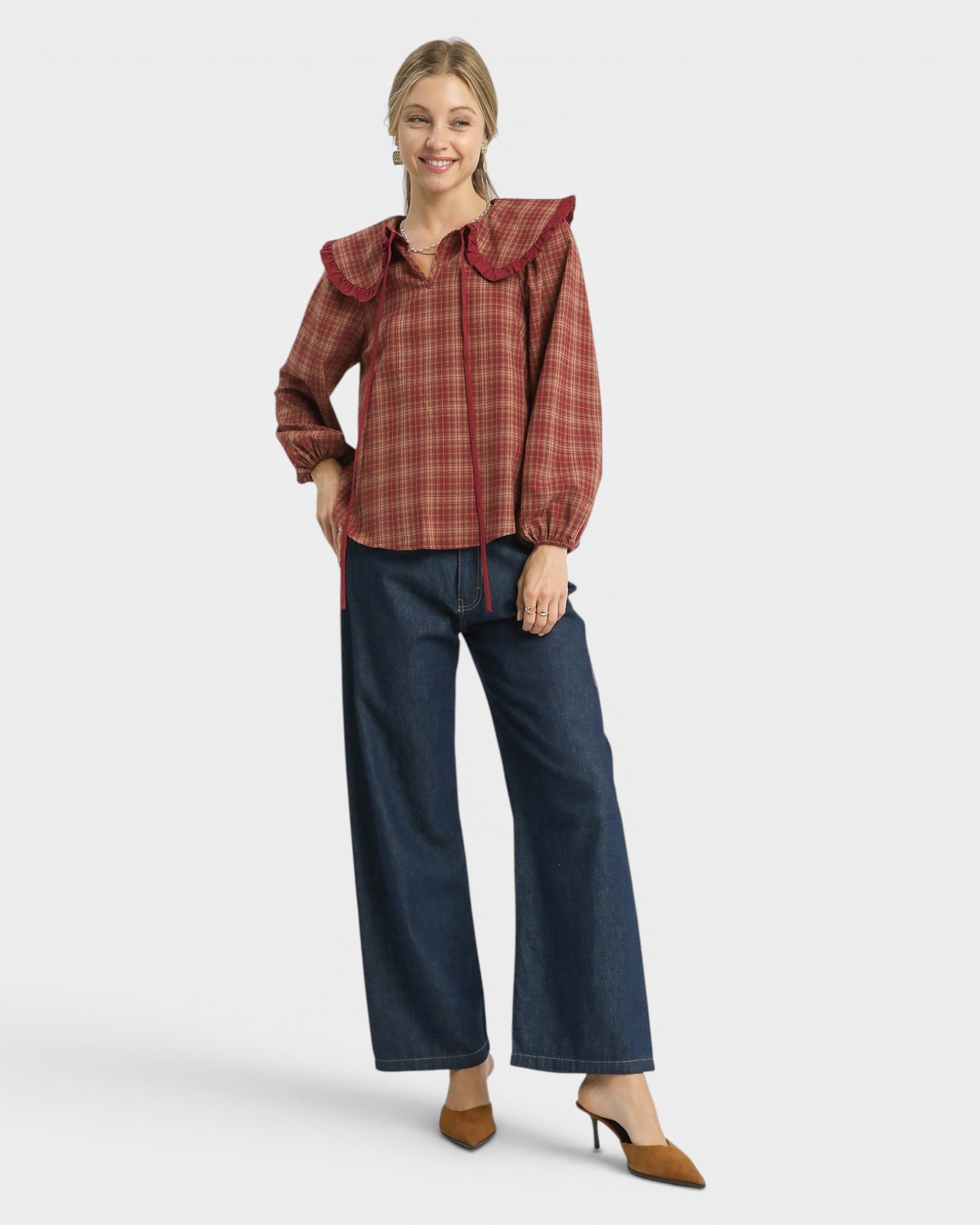Woman wearing a plaid blouse and blue jeans on a white background
