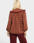 Person wearing a red plaid jacket with a ruffled collar on a white background