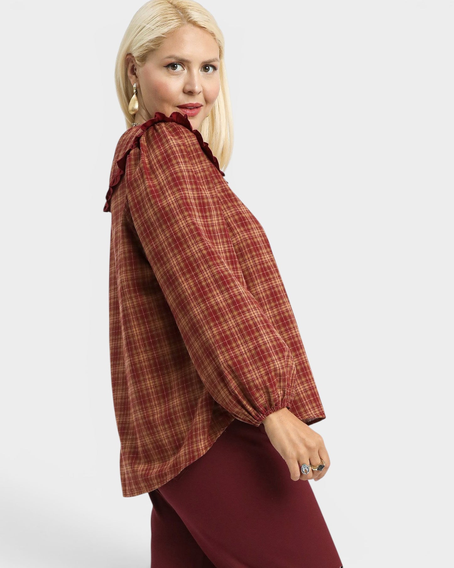 Woman wearing a plaid blouse with a plain background