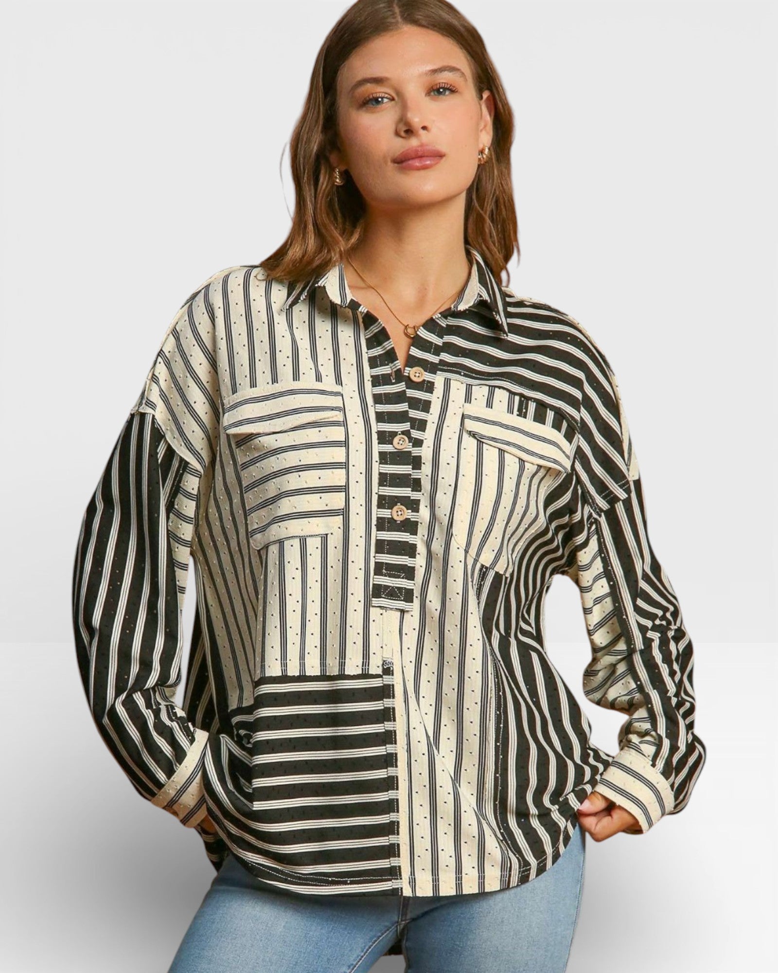 Woman wearing a black and white patterned shirt against a plain background