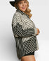 Woman wearing a black and white striped cardigan on a white background