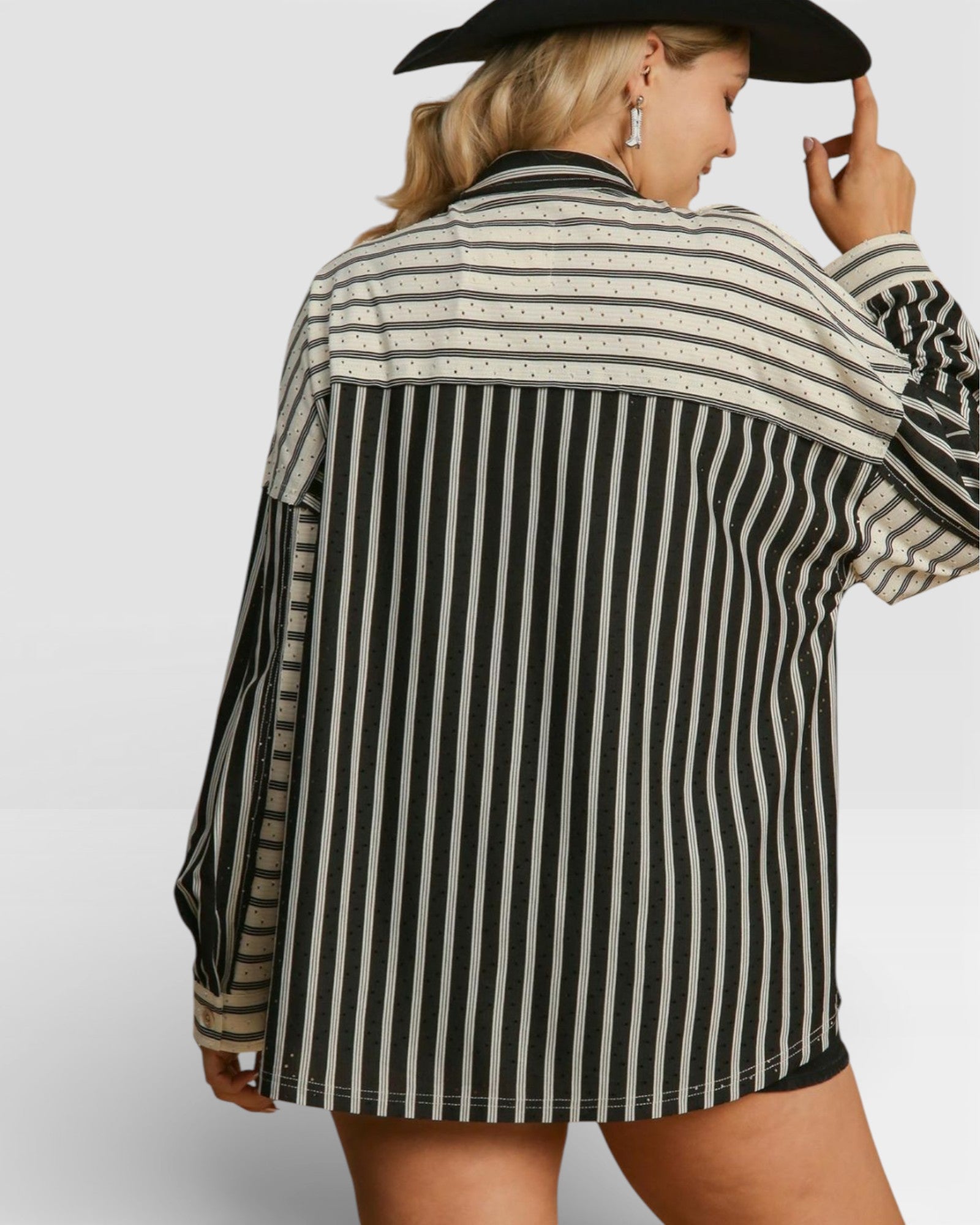 Person wearing a black and white striped shirt with a plain background