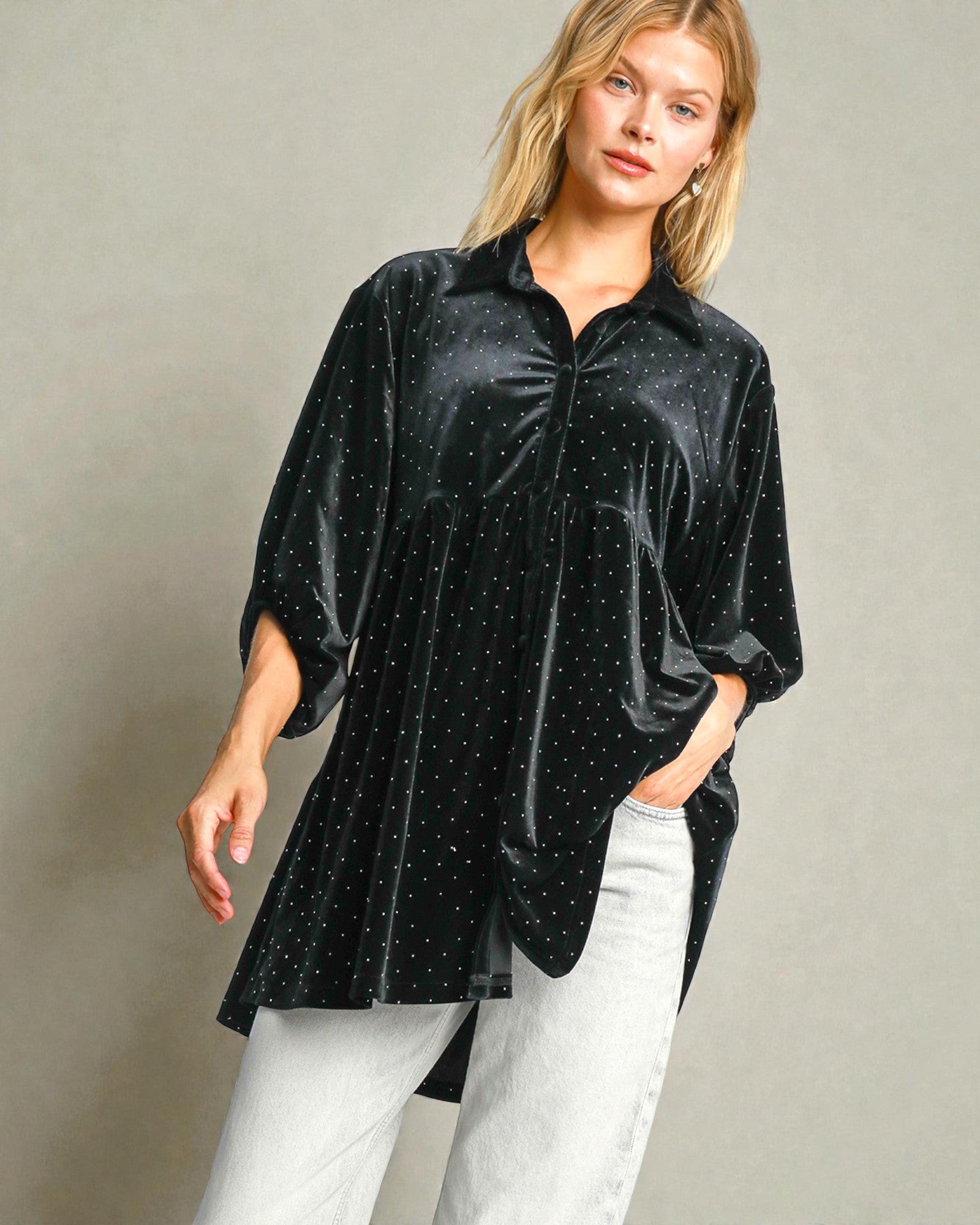 Woman wearing a black velvet shirt with white polka dots on a gray background