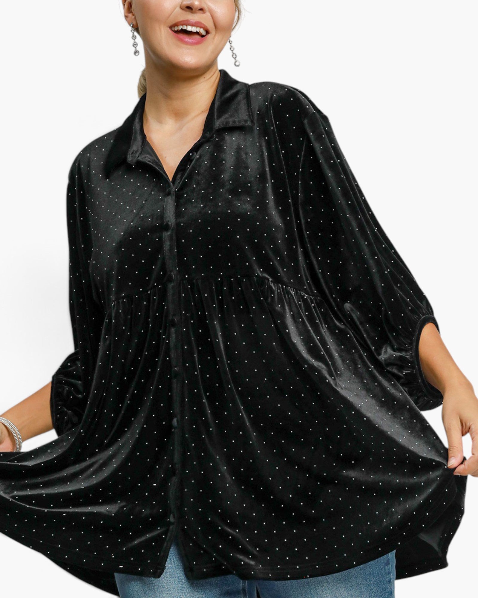 A woman wearing a black velvet button-up shirt with small silver rhinestone dots, paired with blue jeans, shown against a plain white background.