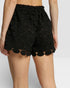 Black scalloped shorts on a plain background