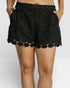 Black scalloped shorts worn by a person on a plain background
