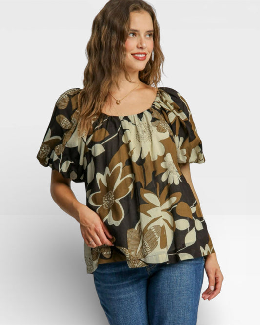 Woman wearing a floral blouse with a plain background