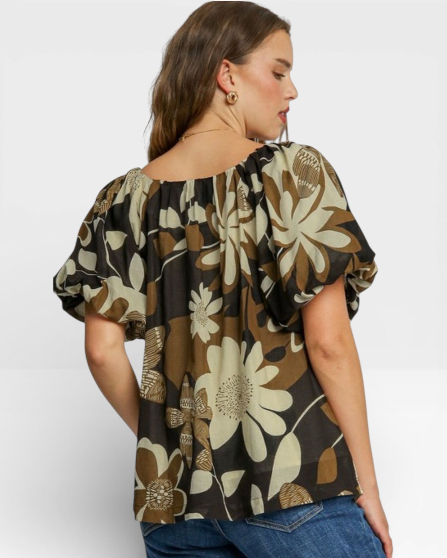 Woman wearing a floral blouse with puff sleeves on a white background